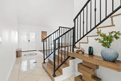 a living room with stairs and a vase with flowers at Premium Queen Room Private Ensuite Bright in Norwalk