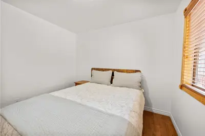 a bed in a white room with a window at Leaf & Needle - Walk to Lake & Village, Picnic Table, Single Story, Fenced Yard in Big Bear Lake