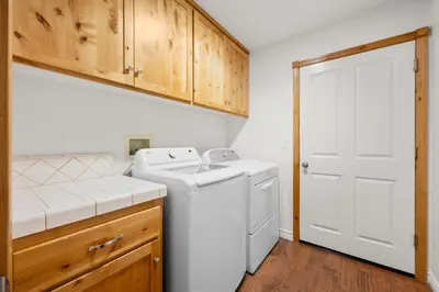 a white laundry room with a washer and dryer at Leaf & Needle - Walk to Lake & Village, Picnic Table, Single Story, Fenced Yard in Big Bear Lake