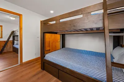 a bedroom with two bunk beds and a mirror at Log Cabin Dream - Log Cabin, Walk to Lake, Fireplace, Deck, BBQ in Big Bear Lake