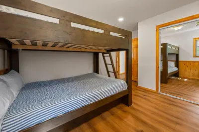 a bedroom with two bunk beds and a mirror at Log Cabin Dream - Log Cabin, Walk to Lake, Fireplace, Deck, BBQ in Big Bear Lake
