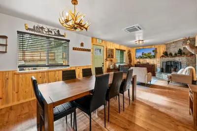 a dining room and living room with a wooden table and chairs at The Hideaway - Near Lake & Village, Hot Tub, Fireplace, AC in Big Bear Lake