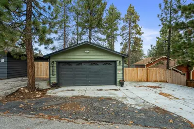 a house with a garage with a fence at The Hideaway - Near Lake & Village, Hot Tub, Fireplace, AC in Big Bear Lake