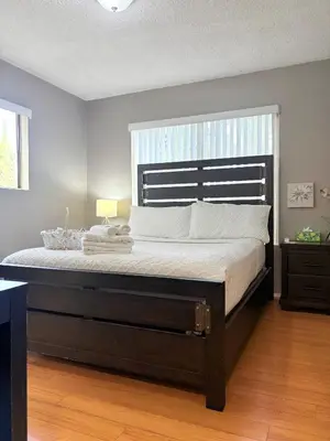 a large bed in a bedroom with a large window at Proper Stays at Melrose - West Hollywood Modern 3-Bedroom Designer Home in Los Angeles