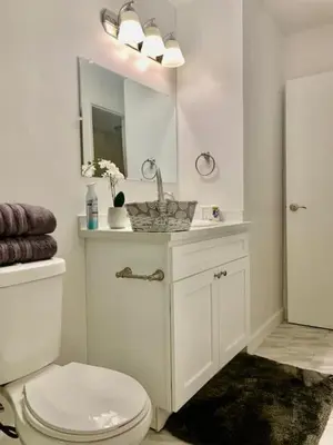 a bathroom with a toilet and a sink and a mirror at Proper Stays at Melrose - West Hollywood Modern 3-Bedroom Designer Home in Los Angeles