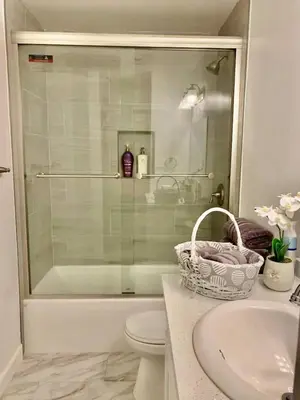a bathroom with a shower and a toilet and a sink at Proper Stays at Melrose - West Hollywood Modern 3-Bedroom Designer Home in Los Angeles