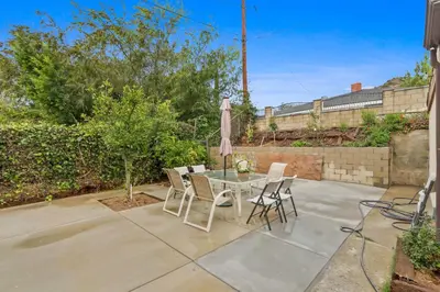 a patio with a table and chairs and an umbrella at New Family House Fanstic View Azusa in Azusa