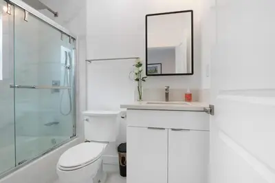 a bathroom with a toilet and a sink and a mirror at New Family House Fanstic View Azusa in Azusa