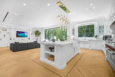 a kitchen with white cabinets and a living room at Spaulding Ave Farmhouse in Los Angeles