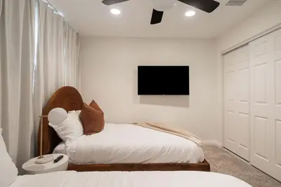 a bedroom with a bed and a tv on the wall at Sunlit Oasis with Heated Pool and Jacuzzi 20 minutes to Disneyland in Placentia