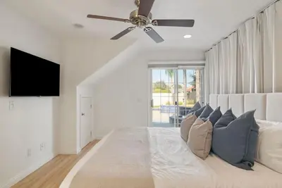 a bedroom with a large bed with a ceiling fan at Sunlit Oasis with Heated Pool and Jacuzzi 20 minutes to Disneyland in Placentia