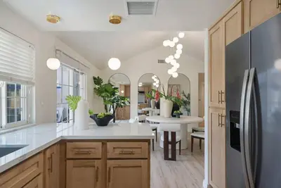 a kitchen with a refrigerator and a dining room at Sunlit Oasis with Heated Pool and Jacuzzi 20 minutes to Disneyland in Placentia