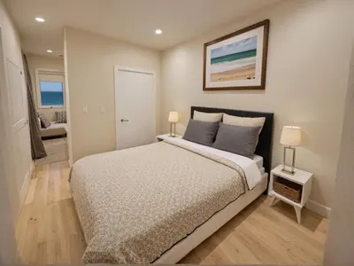 a bedroom with a large bed with two lamps at Modern 4 & 5 BR Townhomes Minutes from Downtown LA in Los Angeles