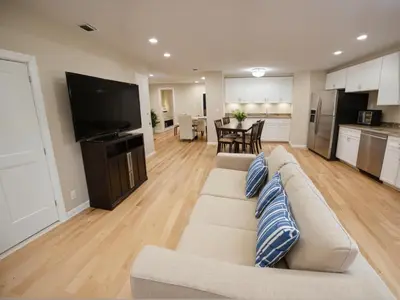 a living room with a couch and a kitchen at Modern 4 & 5 BR Townhomes Minutes from Downtown LA in Los Angeles