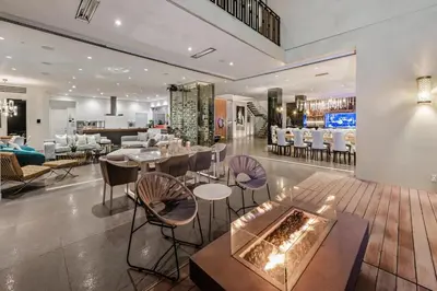 a restaurant with a fireplace in the middle of a room at Alta Royale in Los Angeles