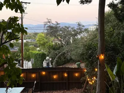 a backyard with a wooden fence and lights at Private getaway in Studio City Hills universal in Los Angeles