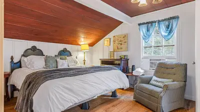 a bedroom with a bed and a chair and a window at Minutes to Lake Arrowhead Village Cozy Secluded Cedar Cove by AvantStay in Lake Arrowhead