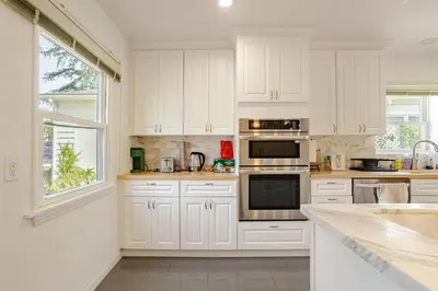 a white kitchen with white cabinets and appliances at Relaxing time in Pasadena in Pasadena