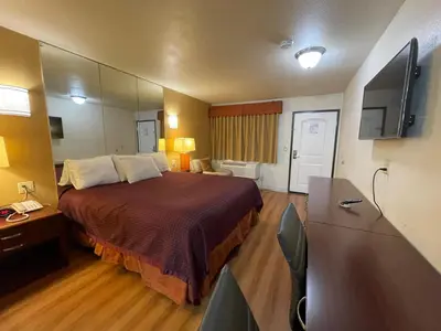 a hotel room with a bed and a television at Sierra Inn in South El Monte