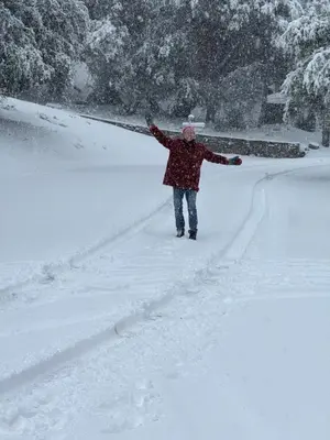 a person standing in the snow with their arms out at Mountain Getaway - Stunning Views in Pine Mountain Club