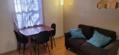 a living room with a couch and a table with blue pillows at The Cozy Corner in Canoga in Canoga Park