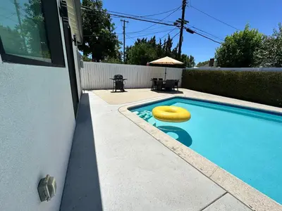 a swimming pool with a yellow frisbee in it at Modern 3BR with King Bed, Gated Pool and BBQ Oasis in West Valley Area Heliport