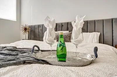a tray with two wine glasses and a bottle on a bed at Modern 3BR with King Bed, Gated Pool and BBQ Oasis in West Valley Area Heliport