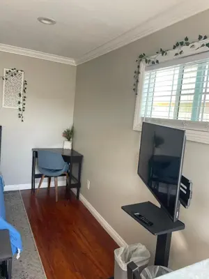 a living room with a tv and a table with a chair at The stay go in Gardena