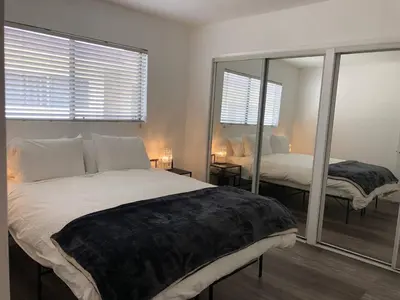 a bedroom with a large bed and a mirror at Modern 1 Bedroom Hollywood Apartment Near Larchmont Village Walk of Fame and Studios in Los Angeles