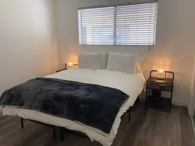 a bedroom with a large bed with a window and two tables at Modern 1 Bedroom Hollywood Apartment Near Larchmont Village Walk of Fame and Studios in Los Angeles