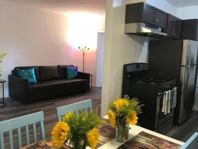 a kitchen and living room with a table with flowers on it at Modern 1 Bedroom Hollywood Apartment Near Larchmont Village Walk of Fame and Studios in Los Angeles