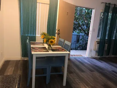 a table with a vase of flowers on top of it at Modern 1 Bedroom Hollywood Apartment Near Larchmont Village Walk of Fame and Studios in Los Angeles