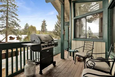 a grill on a screened in porch with a chair at Vivienda De Osos Walk to the Lake Spacious Fawnskin Retreat Chalet in Fawnskin