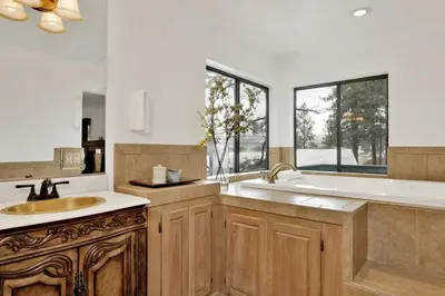 a kitchen with a sink and a tub and windows at Vivienda De Osos Walk to the Lake Spacious Fawnskin Retreat Chalet in Fawnskin