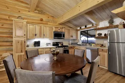 a kitchen with a table and a refrigerator at Ours De Ski Chateau at Snow Summit - Big Bear Basecamp Resort Condo w/ Hot Tub in Big Bear Lake