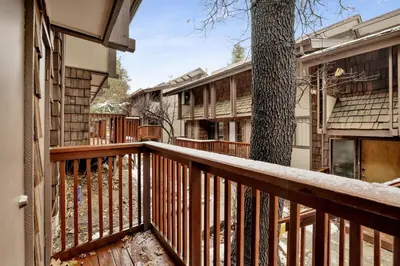 a balcony of a house with a tree at Ours De Ski Chateau at Snow Summit - Big Bear Basecamp Resort Condo w/ Hot Tub in Big Bear Lake