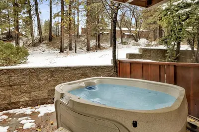 a jacuzzi tub sitting in a yard in the snow at Ours De Ski Chateau at Snow Summit - Big Bear Basecamp Resort Condo w/ Hot Tub in Big Bear Lake
