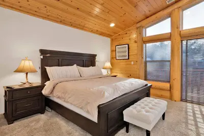 a bedroom with a large bed with a wooden ceiling at Morning Star Log Cabin at Big Bear Ultra-Modern Castle Glen Mountain Chalet in Big Bear Lake