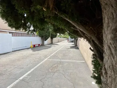an empty parking lot next to a wall at Golden Downey Designer Abode - Poolside Suite in Downey