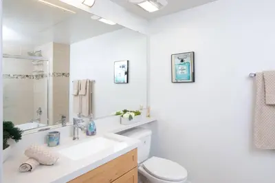 a bathroom with a sink and a toilet and a mirror at Coastal Luxe | Walk to Pier + Free Parking in Los Angeles