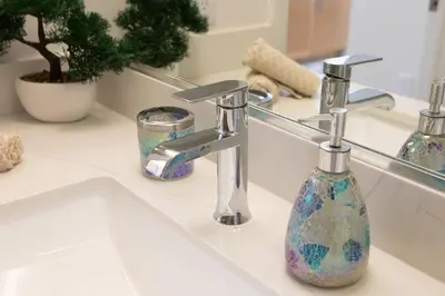 a bathroom sink with a soap dispenser on it at Coastal Luxe | Walk to Pier + Free Parking in Los Angeles