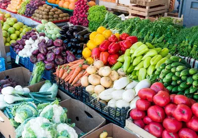 a display of fruits and vegetables in boxes at a market at Coastal Luxe | Walk to Pier + Free Parking in Los Angeles