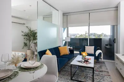 a living room with a blue couch and a table at Stylish Santa Monica Apt Free Parking & Wi-Fi in Los Angeles