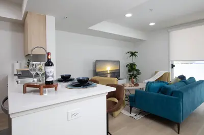 a kitchen and living room with a blue couch at High-End 1BR Oasis | Walk to Ocean & 3rd Street in Los Angeles