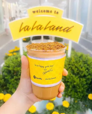 a hand holding a cup of coffee in front of a sign at Laugh in the Lap of Luxury In SM * FREE Parking * in Los Angeles