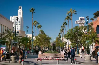 a busy city street with a fountain and palm trees at Santa Monica's Prestige Place *Steps To The Beach* in Los Angeles