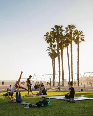 a group of people sitting on the grass at the beach at Wake Up to Waves – Beachside Bliss In Santa Monica in Los Angeles