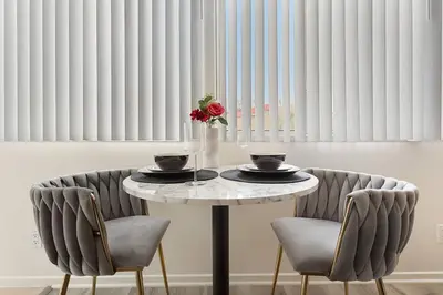 a table with two chairs and a vase with a flower on it at SoCal Luxurious Apt Steps To The Beach & Pier in Los Angeles