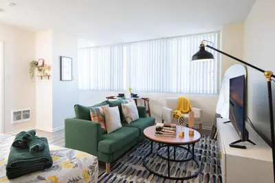 a living room with a green couch and a table at * Prime Location Studio Near Santa Monica Pier * in Los Angeles