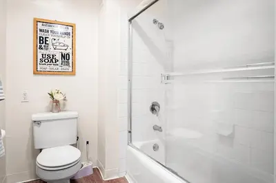 a white bathroom with a toilet and a shower at Beachside Beauty Steps To The Beach & Restaurants in Los Angeles